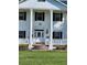 White two-story home with columns and a brick staircase at 15625 State Road 62 St, Parrish, FL 34219