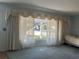 Living room with large windows, sheer curtains and a view of the street at 6709 Mornay Cir, Tampa, FL 33615