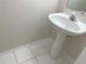 Clean and simple pedestal sink in a small bathroom with white tile floor at 2346 Lake Woodberry Cir, Brandon, FL 33510