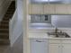 Kitchen with white cabinets, double sink, dishwasher and view of living room and stairs at 2346 Lake Woodberry Cir, Brandon, FL 33510