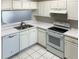 Kitchen with white cabinets, black appliances, and double sink at 2346 Lake Woodberry Cir, Brandon, FL 33510