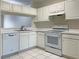 White kitchen with appliances, ample cabinetry and a view of the living room at 2346 Lake Woodberry Cir, Brandon, FL 33510