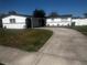 Inviting single-story home with a large concrete driveway and well-kept lawn at 6007 Ambassador Dr, Tampa, FL 33615