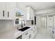 Bright kitchen with white cabinets, black hardware, quartz countertops, and modern appliances at 6007 Ambassador Dr, Tampa, FL 33615
