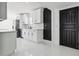 Modern kitchen featuring white cabinetry, stainless steel appliances and a black accent wall at 6007 Ambassador Dr, Tampa, FL 33615