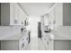 Modern, all-white kitchen features stainless steel appliances, ample counter space, and sleek black hardware at 6007 Ambassador Dr, Tampa, FL 33615