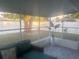 Inviting screened-in porch with stylish decor, offering a relaxing view of the landscaped backyard and outdoor gazebo at 6007 Ambassador Dr, Tampa, FL 33615