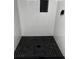 Modern shower with black honeycomb tile flooring and an inset shelf at 6007 Ambassador Dr, Tampa, FL 33615