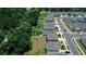 Aerial view showcasing new homes bordering a wooded area, manicured lawns, and neighborhood streets at 7729 Rosewood Garden Loop, Tampa, FL 33637