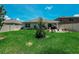 Back yard featuring green grass, landscaping, white vinyl fence, patio, and blue skies with clouds at 7729 Rosewood Garden Loop, Tampa, FL 33637