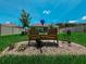 Back yard featuring green grass, landscaping, white vinyl fence, bench, and blue skies with clouds at 7729 Rosewood Garden Loop, Tampa, FL 33637