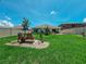 Large backyard with an inviting seating area, surrounded by lush green lawn and a white fence at 7729 Rosewood Garden Loop, Tampa, FL 33637