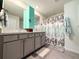 Bathroom with double sinks, modern vanity, and a shower with a decorative curtain at 7729 Rosewood Garden Loop, Tampa, FL 33637