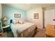 A quaint bedroom features an accent wall, neutral carpet, and a vintage lamp at 7729 Rosewood Garden Loop, Tampa, FL 33637