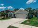 Charming single-story home with a two-car garage, beautiful landscaping, and a spacious driveway on a sunny day at 7729 Rosewood Garden Loop, Tampa, FL 33637