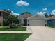 Lovely one-story home featuring manicured landscaping, charming shutters, and a well-maintained lawn under a bright sky at 7729 Rosewood Garden Loop, Tampa, FL 33637