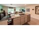 Open kitchen with island, granite countertops, stainless steel appliances, and adjacent dining area at 7729 Rosewood Garden Loop, Tampa, FL 33637