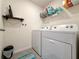 Efficient laundry room with modern washer, dryer, shelving, and practical storage solutions at 7729 Rosewood Garden Loop, Tampa, FL 33637