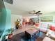 This well-lit living room features tile floors, a ceiling fan, and an open floor plan at 7729 Rosewood Garden Loop, Tampa, FL 33637