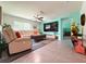 Living room with a large TV screen and tile flooring at 7729 Rosewood Garden Loop, Tampa, FL 33637