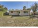 Large backyard with a view of the back of the house and a wooden fence at 5023 Thames Dr, New Port Richey, FL 34652