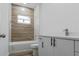 Clean bathroom with white vanity, bathtub and wood-look tile at 10625 Ayear Rd, Port Charlotte, FL 33981