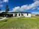 White house with black roof, landscaping, and driveway at 10625 Ayear Rd, Port Charlotte, FL 33981