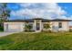 White single-story house with a gray roof, two-car garage, and landscaping at 10625 Ayear Rd, Port Charlotte, FL 33981