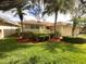 House exterior showcasing landscaping, a red door, and palm trees at 2253 Heron Cir, Clearwater, FL 33762