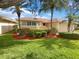 House exterior showcasing landscaping, a red door, and palm trees at 2253 Heron Cir, Clearwater, FL 33762