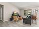 Living room with gray sofa, wood chair, large TV, and wood floors at 9231 Freedom Hill Dr, Seffner, FL 33584