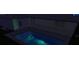 Backyard pool and patio with a covered porch. The pool is illuminated with colored lights at 7384 Van Lake Dr, Englewood, FL 34224