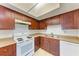 Dark wood kitchen cabinets, white appliances and tile floor at 12229 Eldon Dr, Largo, FL 33774