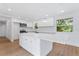 Modern kitchen with white cabinets, large island, and stainless steel appliances at 18839 Aripeka Rd, Hudson, FL 34667