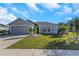 Gray house with two-car garage, landscaping, and a sidewalk at 1315 Gangplank Dr, Valrico, FL 33594