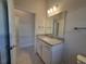 Modern bathroom with granite countertop, white cabinets, and tile flooring at 7006 162Nd E Pl, Parrish, FL 34219