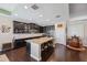 Open kitchen with large island, dark wood cabinets, and granite countertops at 1726 Cameron Court, Trinity, FL 34655