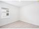 Empty bedroom with white walls, wood-look tile flooring, and window with blinds at 104 Runaway Field Ave, Nokomis, FL 34275