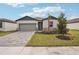 Attractive curb appeal with landscaping, paver driveway, and a gray garage door at 104 Runaway Field Ave, Nokomis, FL 34275