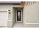 Front entryway with a black door, coach light, and light green siding at 117 Runaway Field Ave, Nokomis, FL 34275
