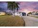 White single-story home with a gray garage door and palm trees at 4059 Orient Dr, Hernando Beach, FL 34607