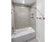 Simple bathroom with a shower/tub combo and gray tile at 17827 Turning Leaf Cir, Land O Lakes, FL 34638