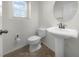 Clean bathroom with pedestal sink, toilet and tiled floor at 8863 White Sage Loop, Lakewood Ranch, FL 34202
