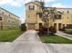 Front view of a three-story townhome with a two-car garage and landscaping at 8863 White Sage Loop, Lakewood Ranch, FL 34202
