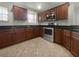 Modern kitchen with dark wood cabinets, granite countertops, and stainless steel appliances at 8863 White Sage Loop, Lakewood Ranch, FL 34202