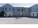 Front view of a light blue, two-story townhome with attached garage and palm trees at 3919 Cape Haze Dr # 503, Rotonda West, FL 33947