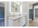 Bright bathroom with a double sink vanity, gold fixtures, and a sleek, modern, backlit mirror at 6370 Conniewood Sq, New Port Richey, FL 34653