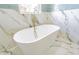 Relaxing bathroom with a stand alone tub, gold faucet, and gold accents at 6370 Conniewood Sq, New Port Richey, FL 34653