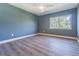 Cozy bedroom with light blue walls, wood floor, ceiling fan, and a window at 6370 Conniewood Sq, New Port Richey, FL 34653
