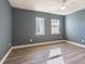 Cozy bedroom featuring contemporary ceiling fan, hardwood floors, and dual windows offering natural light at 6370 Conniewood Sq, New Port Richey, FL 34653